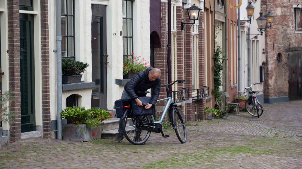 Man sluit fietstassen in stad