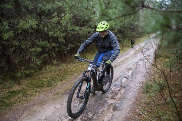 mountainbiker op e-mtb met winterkleding fietst op zandpad