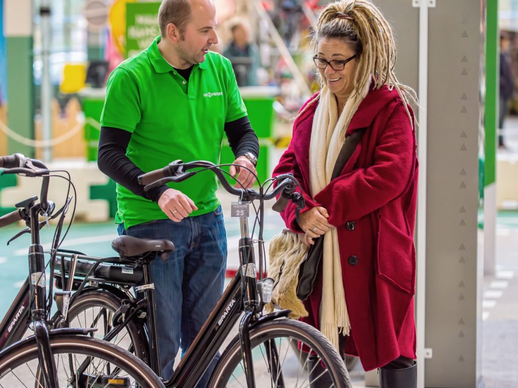 Vrouw krijg e-bike advies van fietsexpert